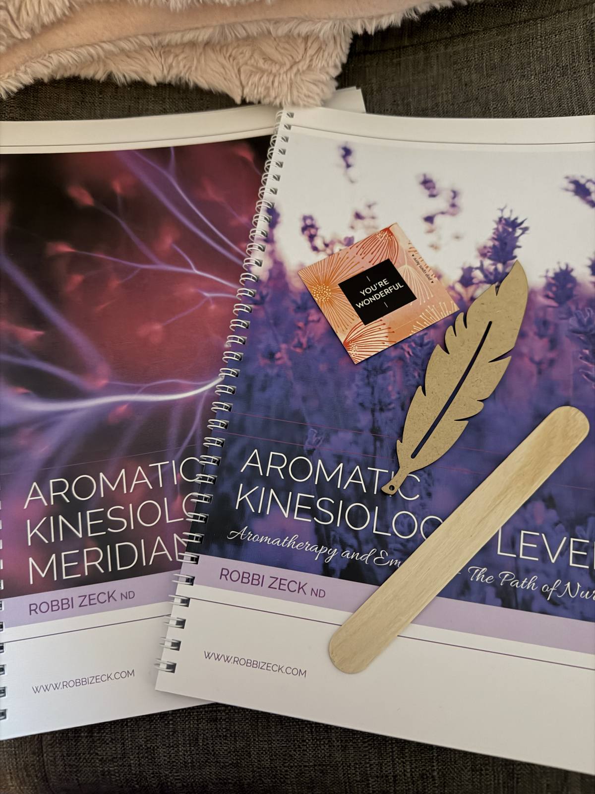 The Aromatic Kinesiology training manual with lavender and a feather