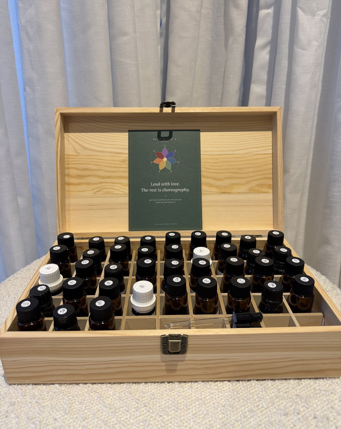 The essential oil kit open, with an In Her Rhythm card resting inside the lid