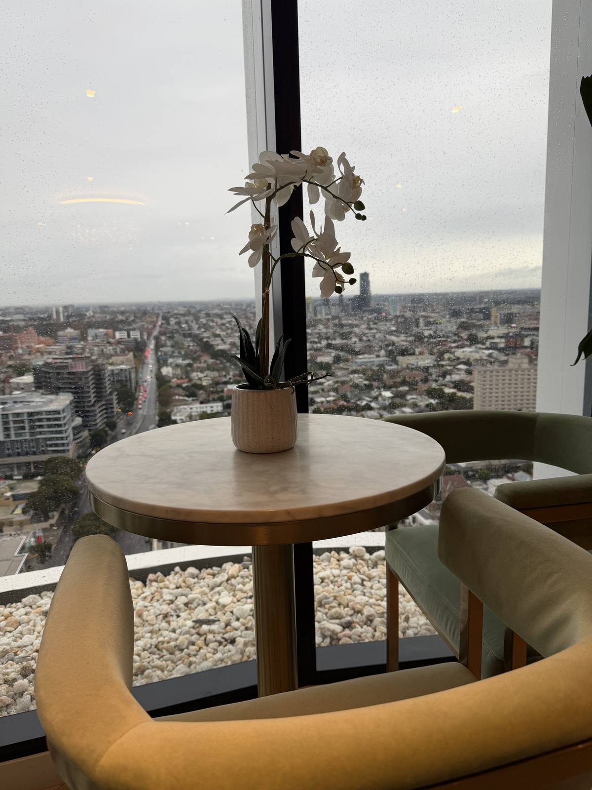 Two chairs by a window looking over the city